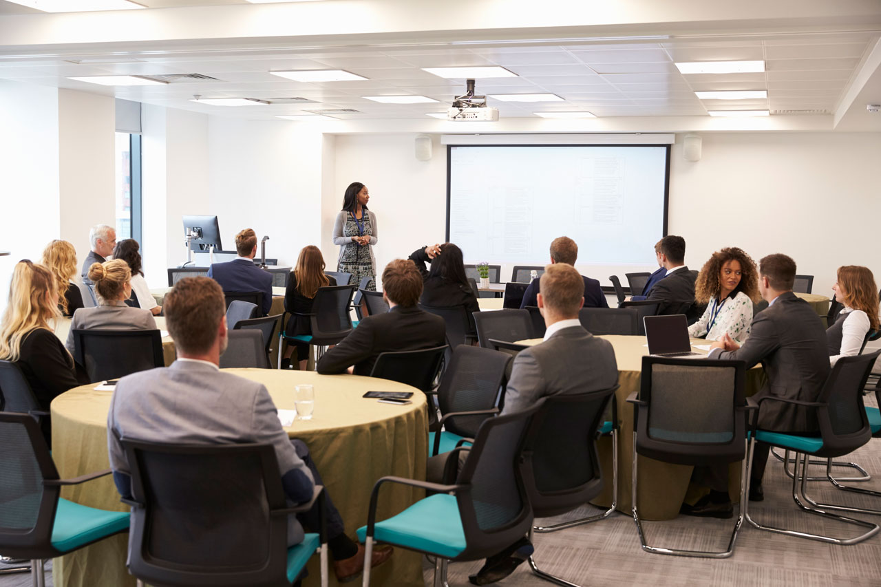 A presenter leading a Social Security benefits workshop in Brentwood, addressing a group of attendees in a conference room.