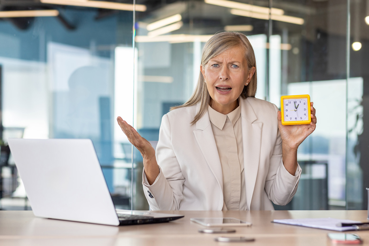 Confused senior woman holding clock, symbolizing decisions around Social Security claiming age